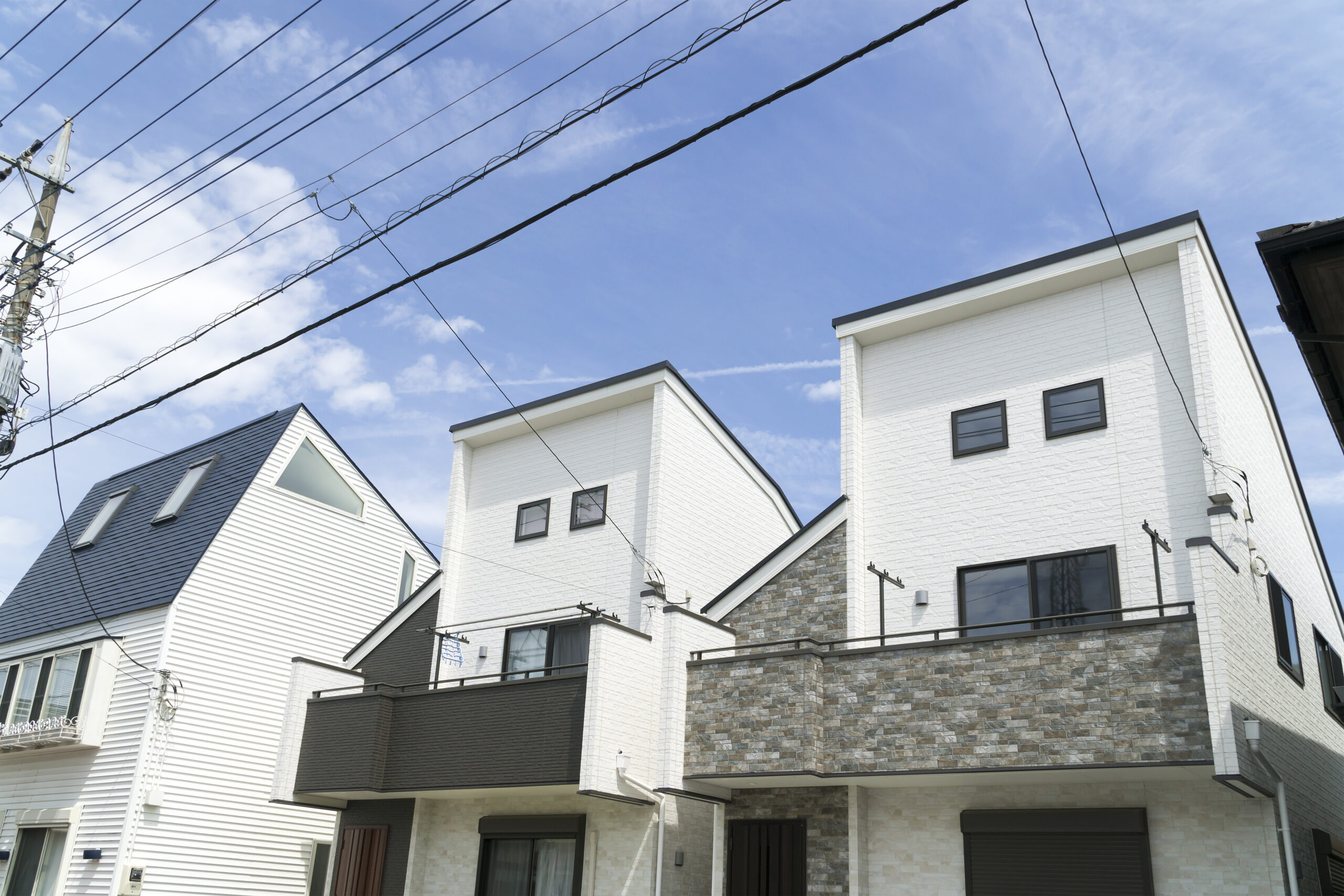 都市部の狭小地に建つ新築住宅街の見上げ構図