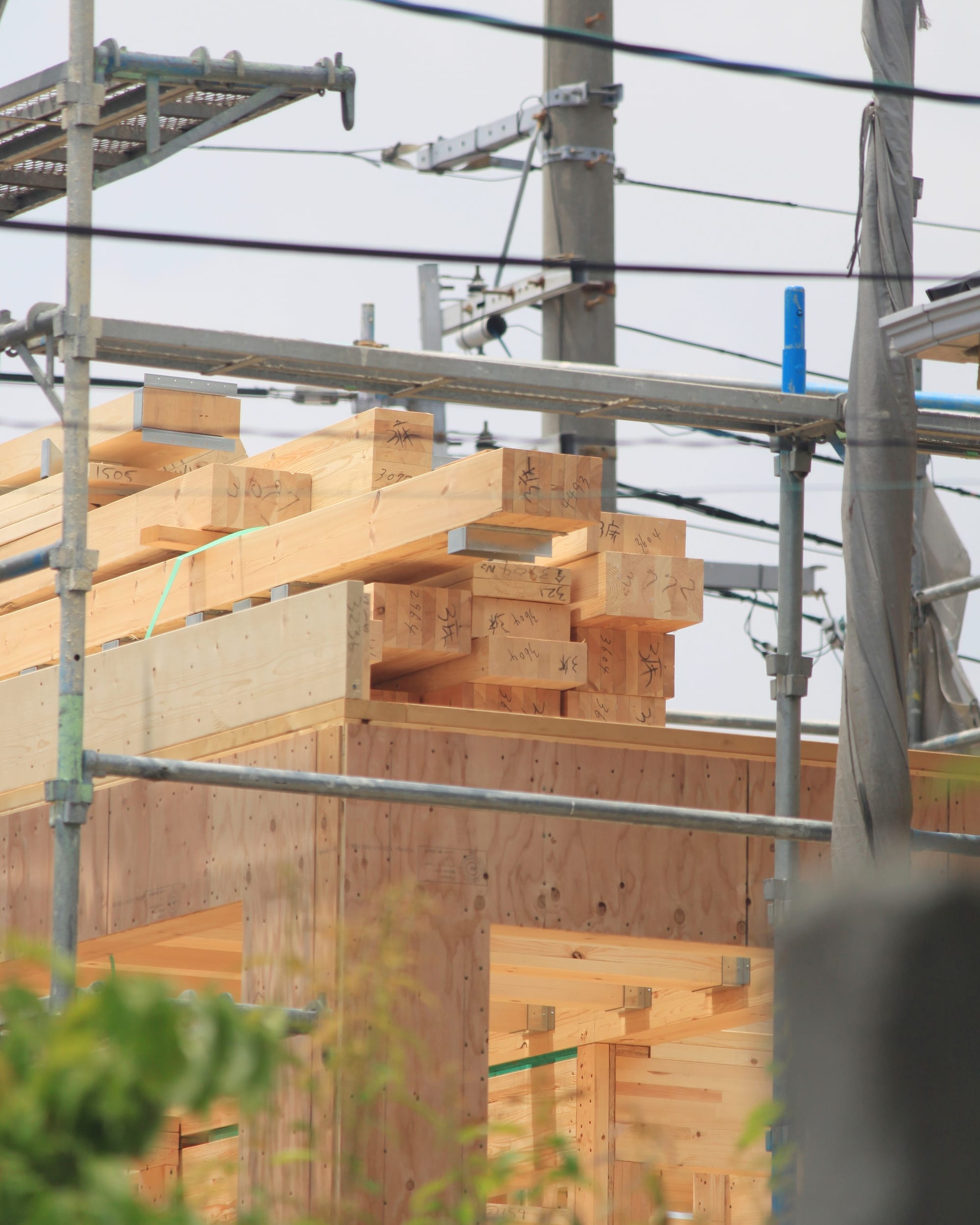 足場を組み木材を搬入した狭小地の施工現場（デモ）